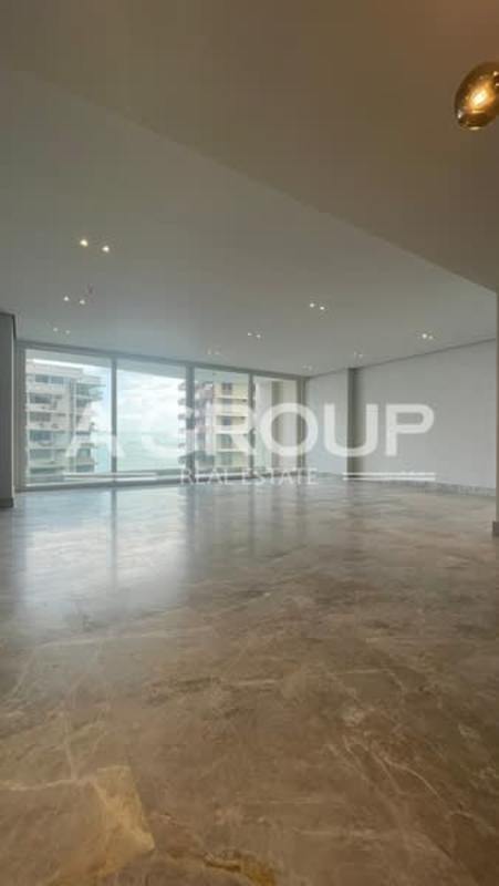 Large modern living room with marble flooring and panoramic windows overlooking ocean and city Punta Paitilla