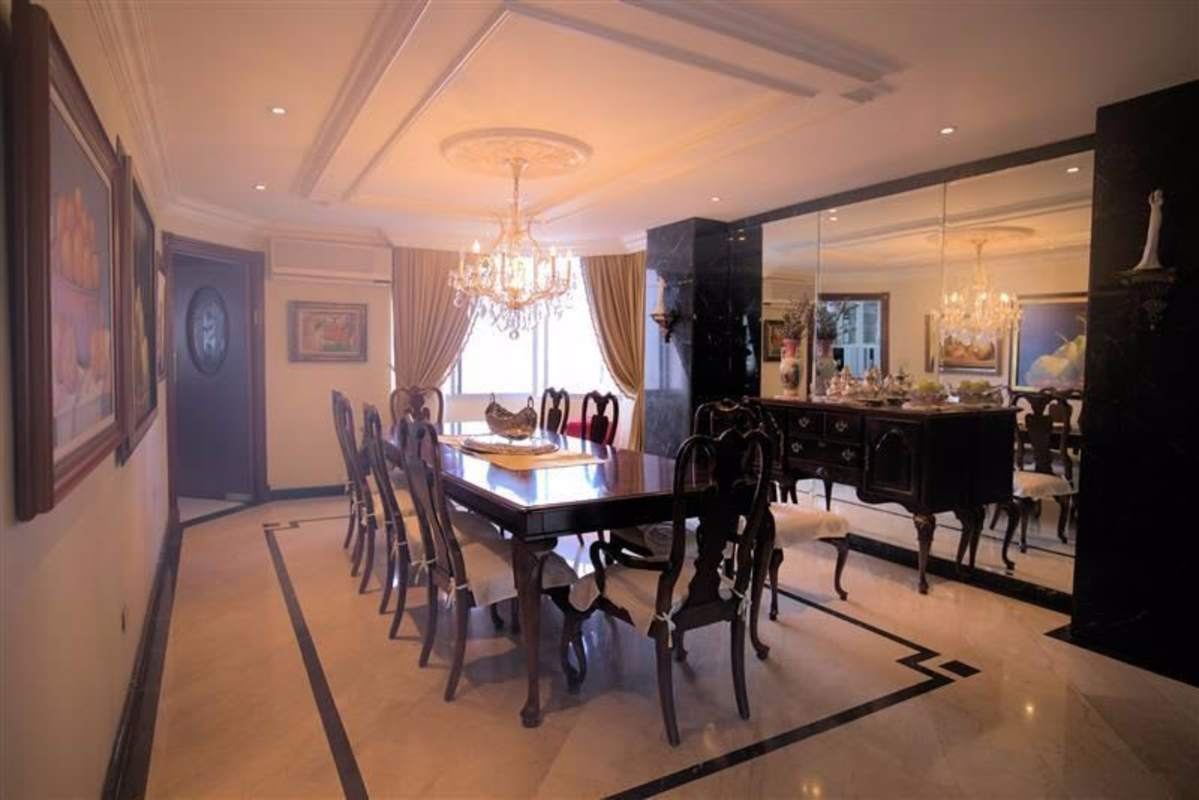 Traditional style dining room with marble floors, mirrored wall and chandelier in PH Lalique Punta Paitilla Panama City