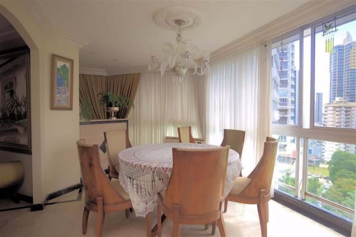 Dining area with panoramic window, chandelier, marble floors overlooking Panama skyline in PH Lalique