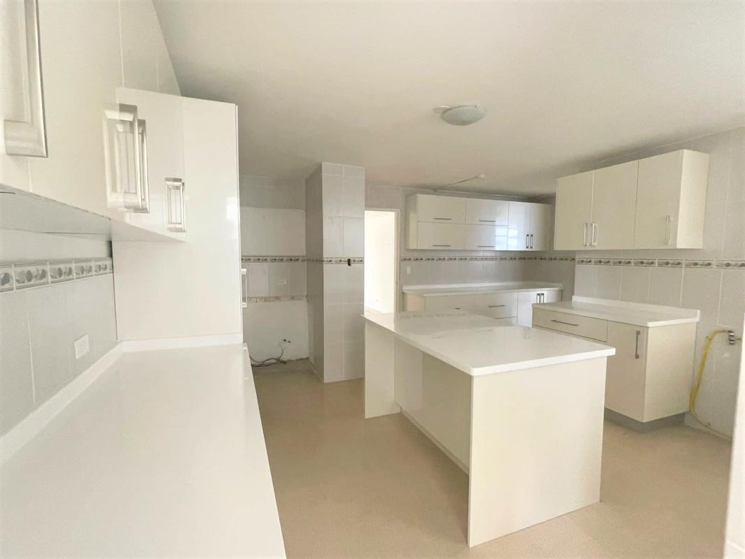 Bright large kitchen with white cabinetry and decorative backsplash PH Savoy