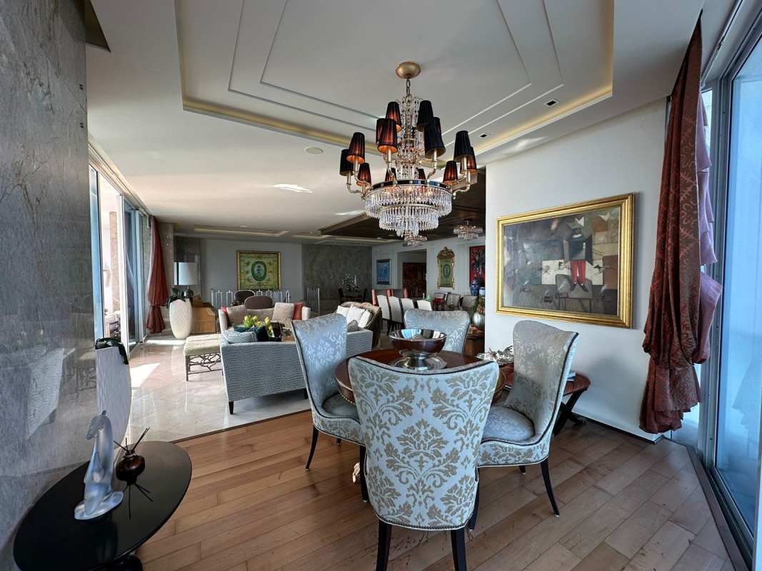 Elegant open living and dining room with chandeliers and city views at The Point Punta Paitilla Panama