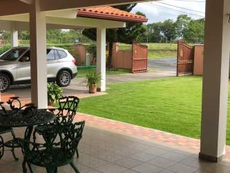 Covered patio with dining table and garden view in Coronado house for sale
