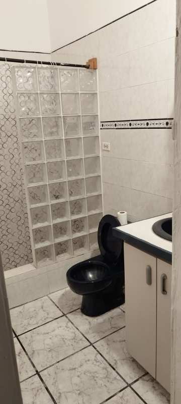 Bedroom with yellow walls, iron bed frame, AC unit, window blinds in Coco del Mar Panama