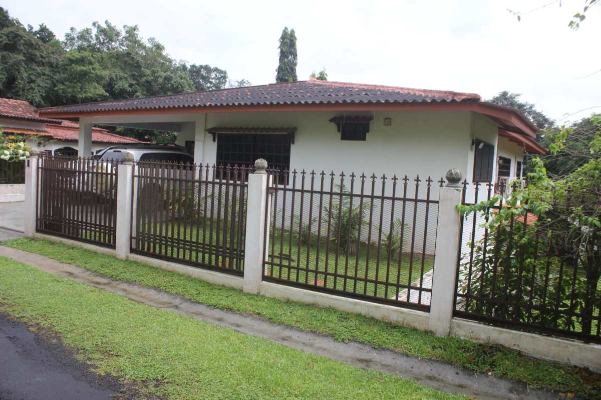 Front view with tile roof, iron fence, carport, garden and sidewalk in Quinta Valentina Las Lajas Panama