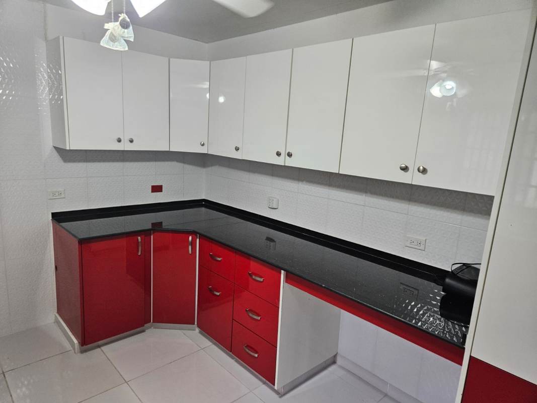 Spacious kitchen with sleek cabinets, black countertops, ceiling fan at Quinta Valentina Las Cumbres Panama
