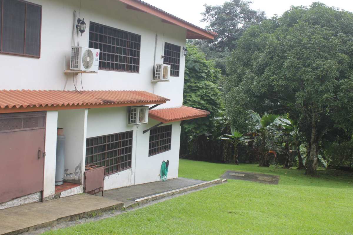 Two-story house with iron gates, red tile roof, spacious fenced garden in Quinta Valentina Las Cumbres Panama