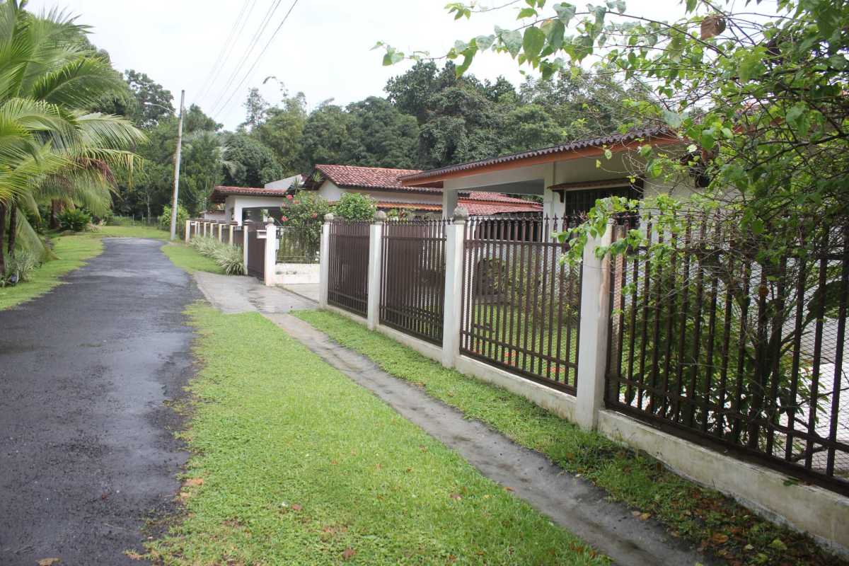 Bungalow style house with garden, metal fence, covered porch, and lush surroundings in Panama City