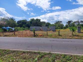 Rural fenced property with mountainous backdrop and paved road frontage in Santo Domingo Panama