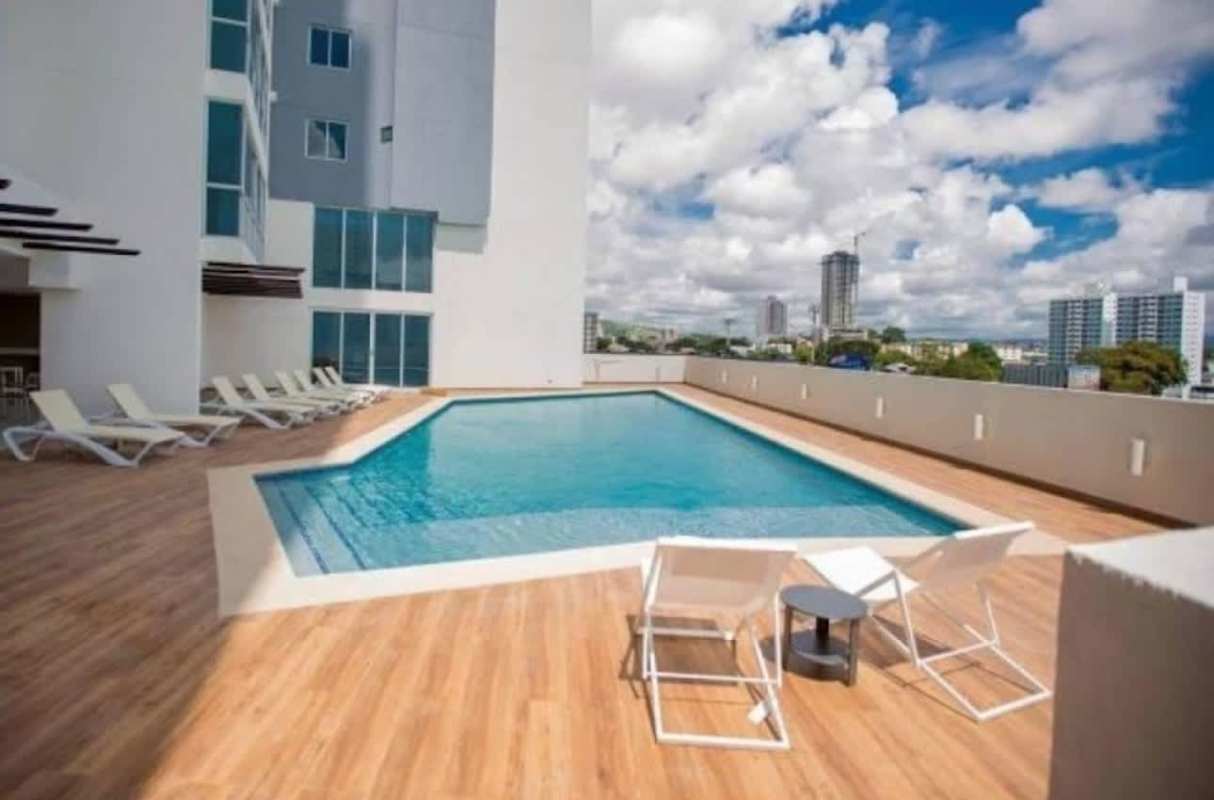 Bedroom with pink bedding, AC unit, large window, natural light PH Carrasquilla Park Panama City