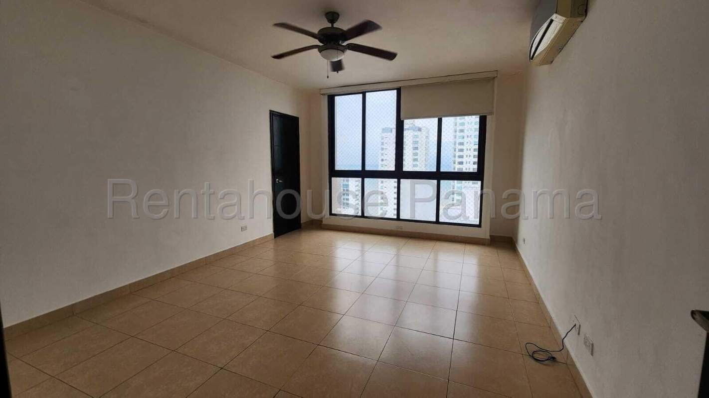 Spacious living room with floor-to-ceiling windows and balcony overlooking Pacific Ocean