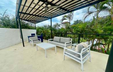 Modern dining space with glass doors open to terraces and gardens at luxury beach villa Panama