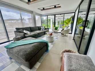 Spacious living area with double-height ceilings, large windows and modern coastal decor at Costa Esmeralda villa Panama