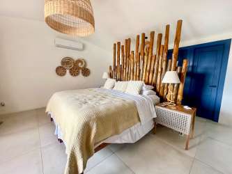 Spacious master bedroom with large windows, garden views and ensuite bathroom beach villa Costa Esmeralda Panama