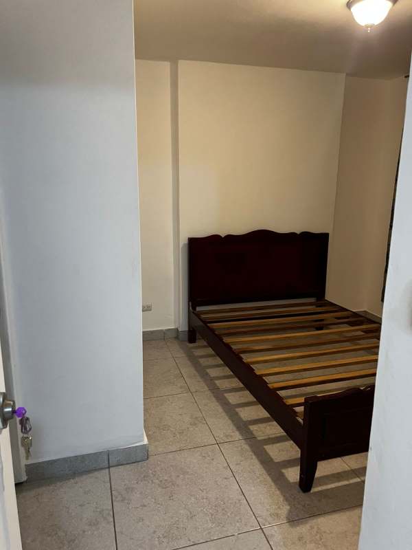 Minimalist bedroom with wooden bed frame tiled floor PH Mystic Hills El Crisol Panama