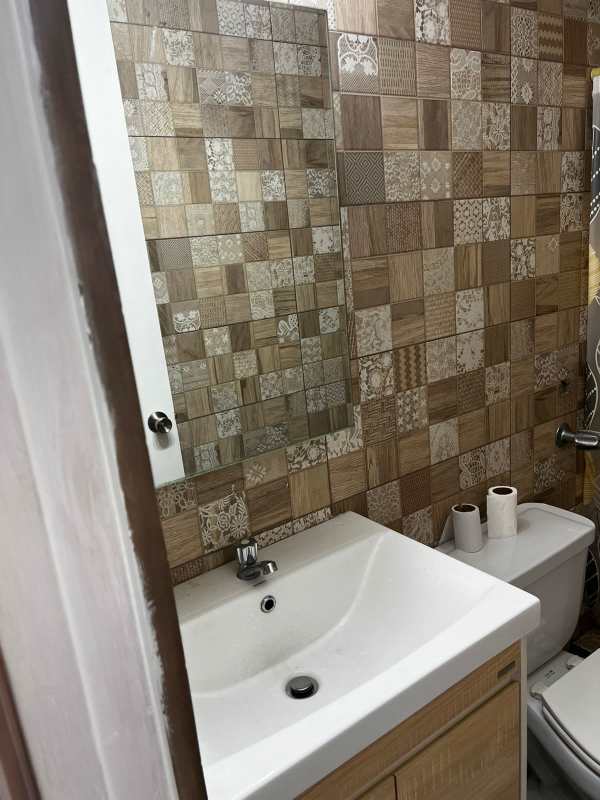 Minimalist bedroom with plain white walls, tiled floor, wooden bed frame PH Mystic Hills Panama