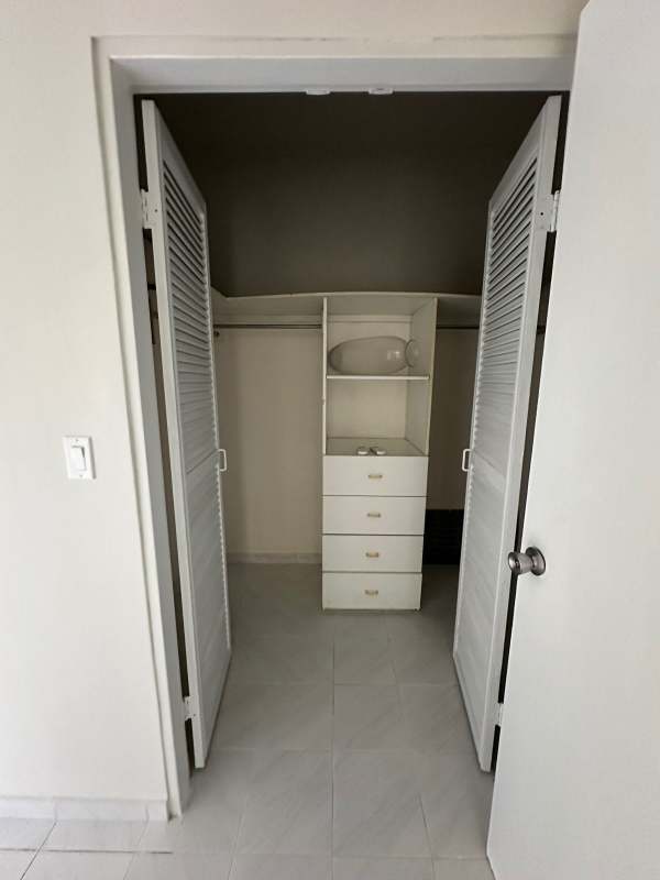 Bedroom with large window, city skyline view, built-in closet at Vista Tower Panama City.