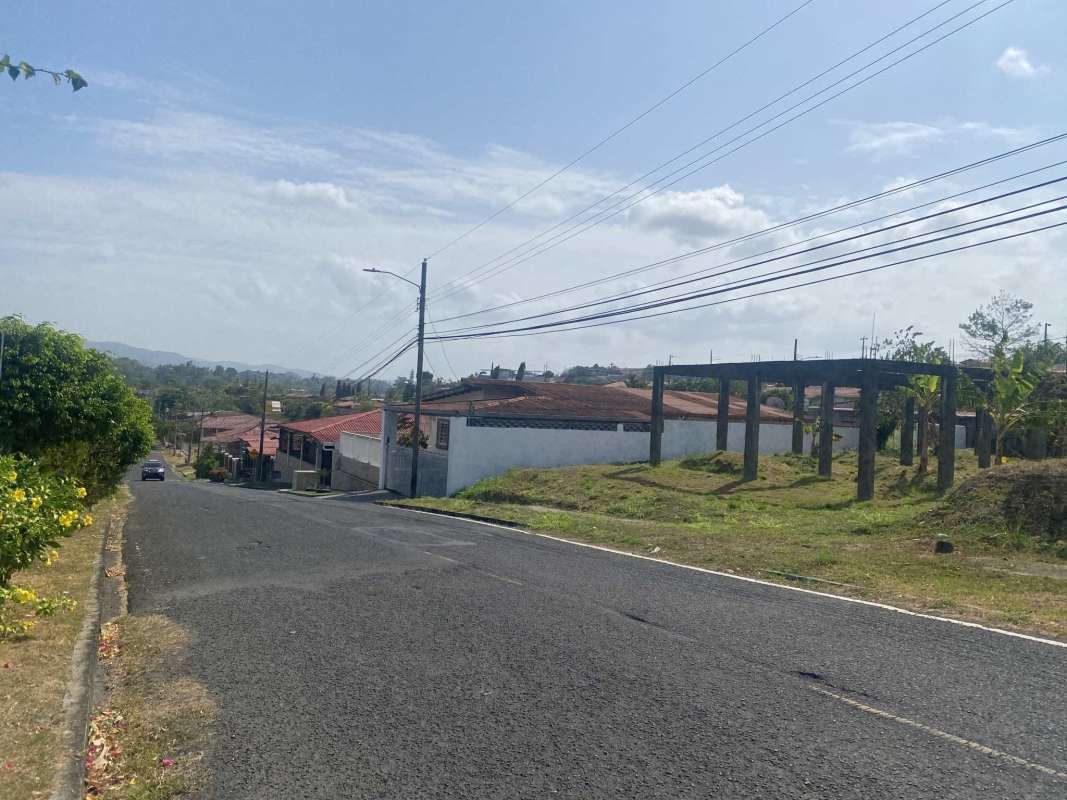 Suburban street with utility poles and vacant lot Villa Alpina Panama