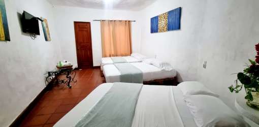 Large guest bedroom with multiple beds TV traditional tile floor Playa Malibu Gorgona Panama vacation rental