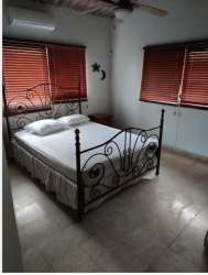 Bedroom with wood beams, AC, king bed and rustic style in beach villa rental Panama