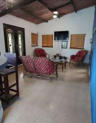 Traditional living room with arched windows, wood ceiling beams, TV in Coronado vacation rental