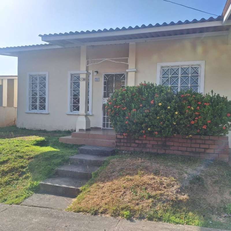 Front yard with porch, garden, flower bushes, and security on windows in Residencial Los Laureles Villa Zaita