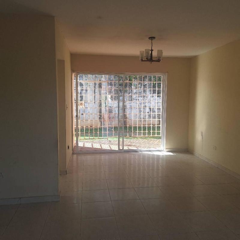 Living room with sliding doors, garden view, and tiled floor inside Los Laureles Villa Zaita Panama
