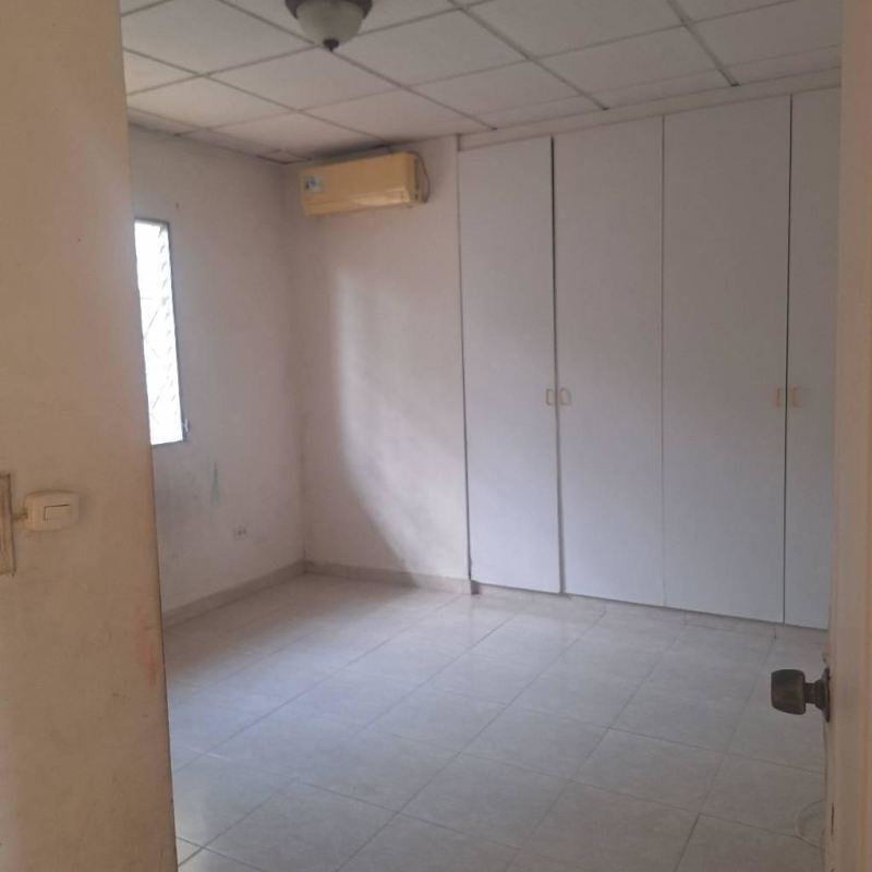 Bedroom with closet space, window with bars and AC unit in gated Los Laureles Villa Zaita Panama City