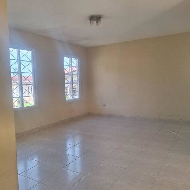 Living room with sliding glass door with security bars opening to backyard, Los Laureles Villa Zaita Panama City