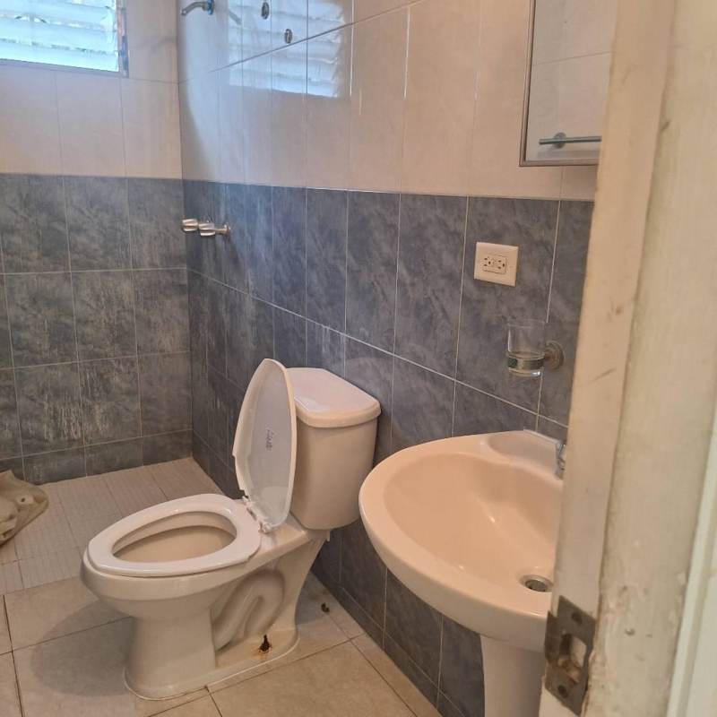 Bathroom with tiled walls, shower, pedestal sink and toilet Los Laureles Villa Zaita house rental Panama