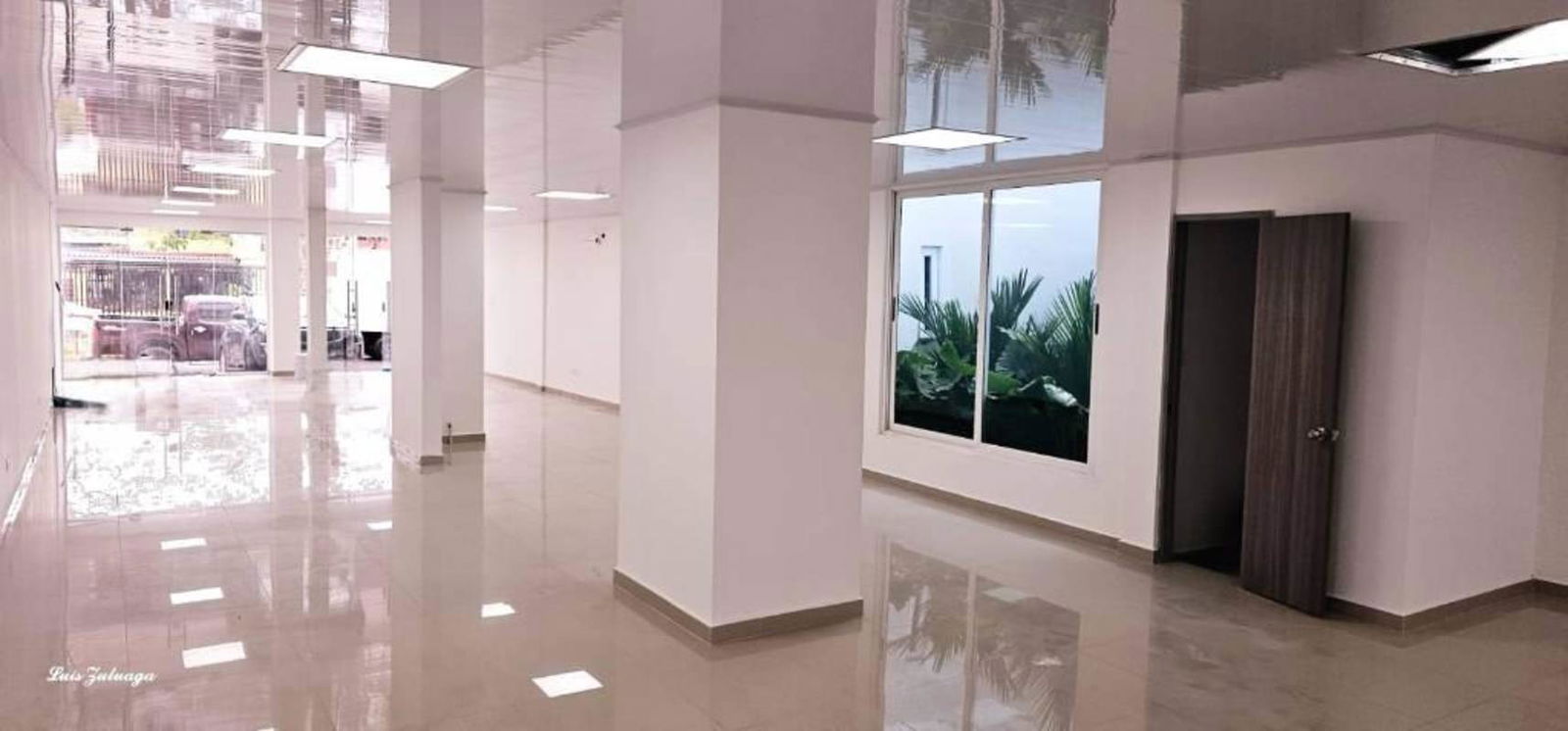 Spacious commercial unit with glossy tile, suspended ceiling lights, large window garden view in Panama City