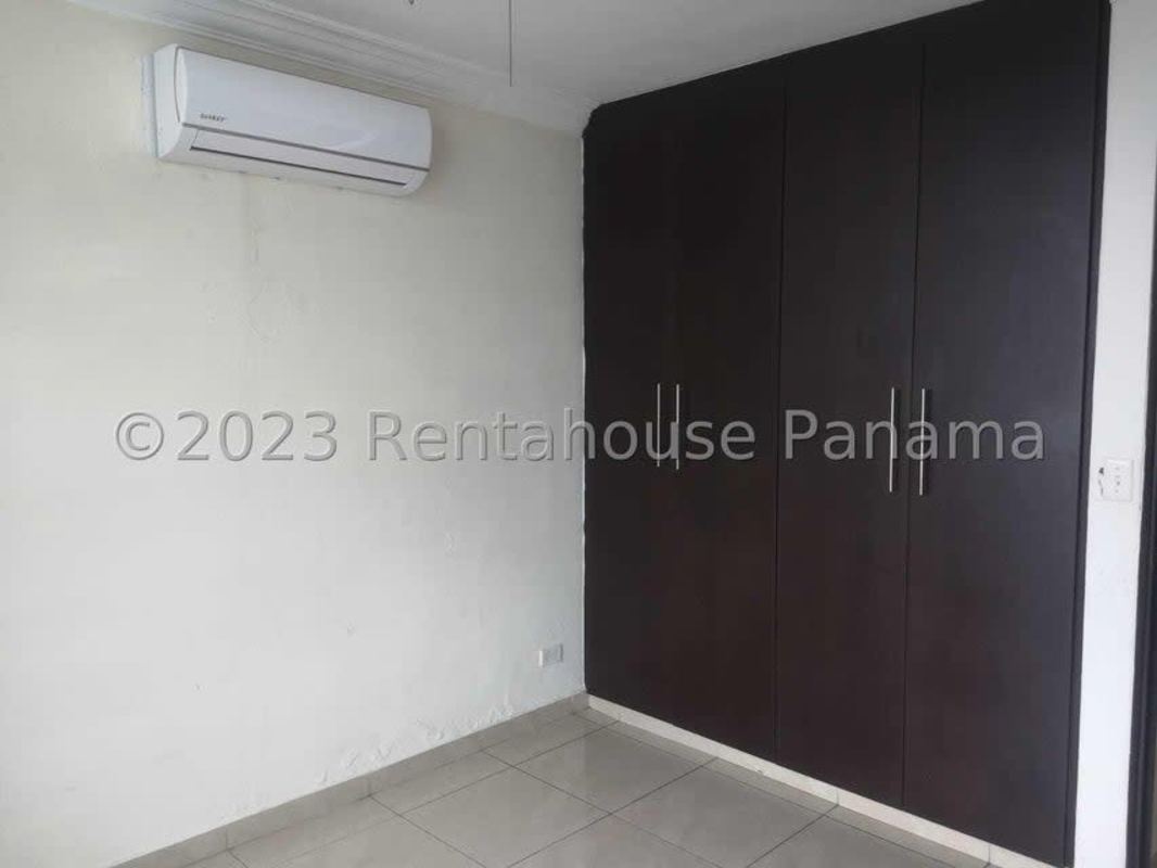 Spacious living area with stone accent wall and tile flooring at Villa de Las Fuentes