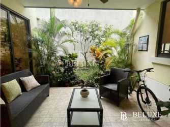 Glass enclosed indoor terrace with garden plants and seating in PH River Valley Panama Pacifico