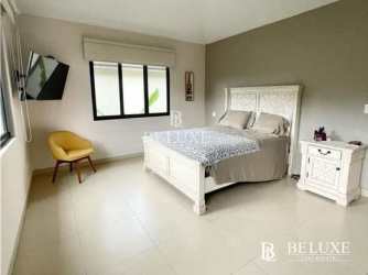 Bedroom with large window, neutral colors, wall-mounted TV in PH River Valley Panama Pacifico