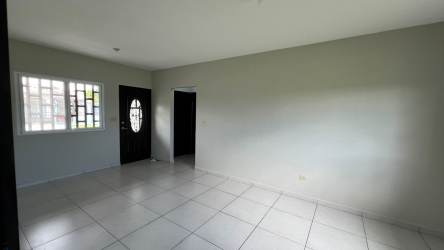 Spacious living room with ceramic tile flooring and windows in Boquerón rental home