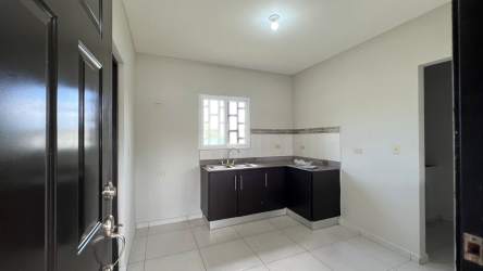 Minimalist kitchen with black cabinets and stainless sink in Boquerón rental house
