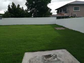 Private backyard with green lawn and fenced boundary ideal for commercial use