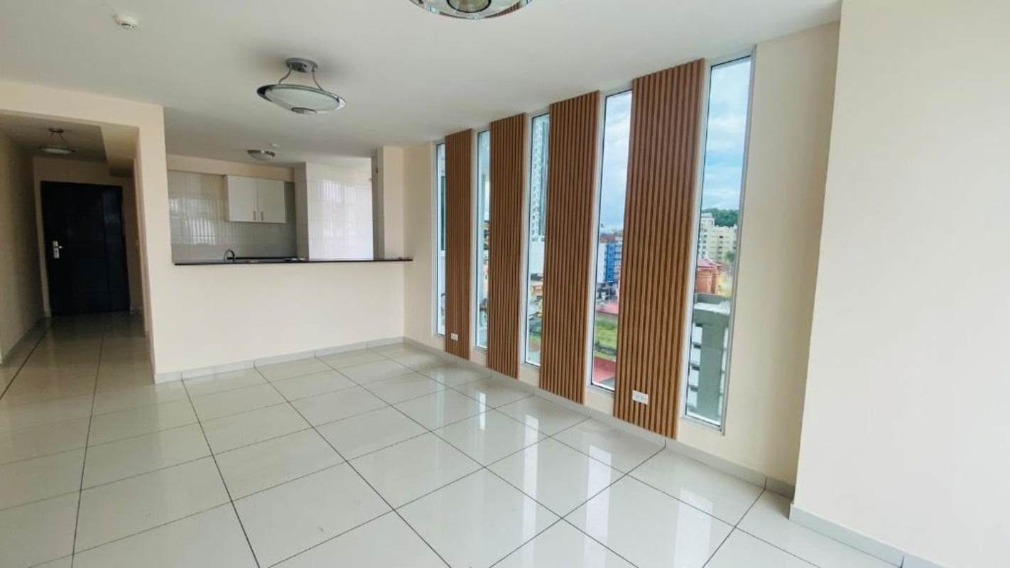 Minimalist open kitchen with black granite countertops and tiled walls Bella Vista apartment Panama City