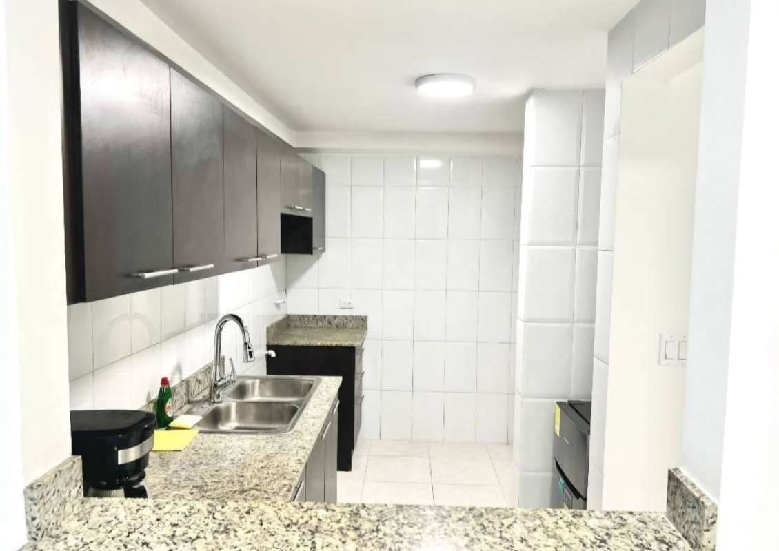 Kitchen with granite counter double sink and wood cabinets Edison Park apartment