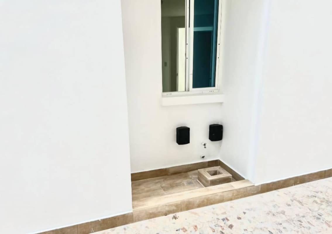 Modern laundry area with tile walls and service window in Edison Park Plaza Edison apartment