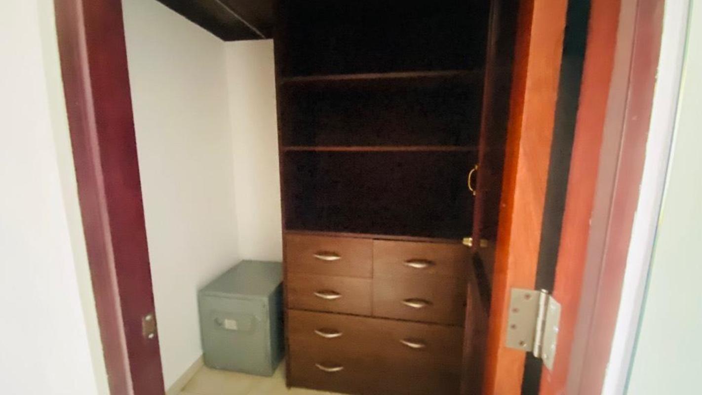 Closet with dark wood shelves, drawers, and safe in house for rent Villa de las Fuentes El Dorado Panama
