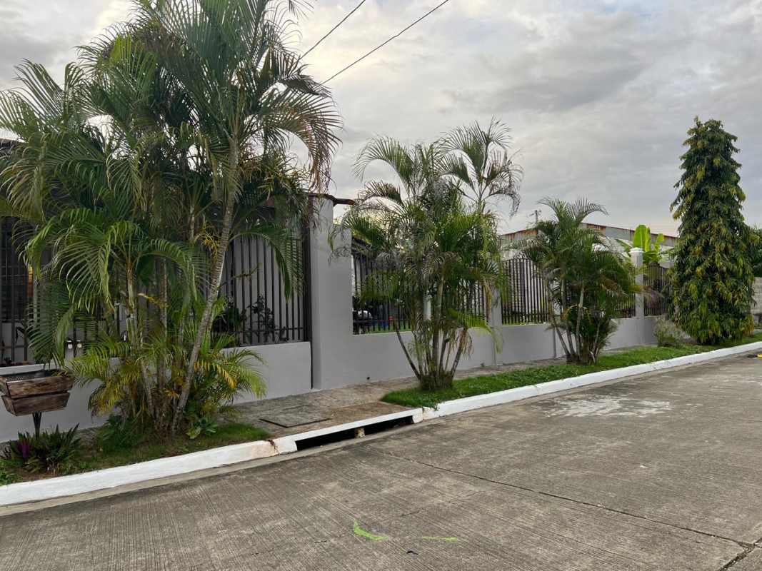 House exterior with covered carport, metal gate, potted plants in La Riviera