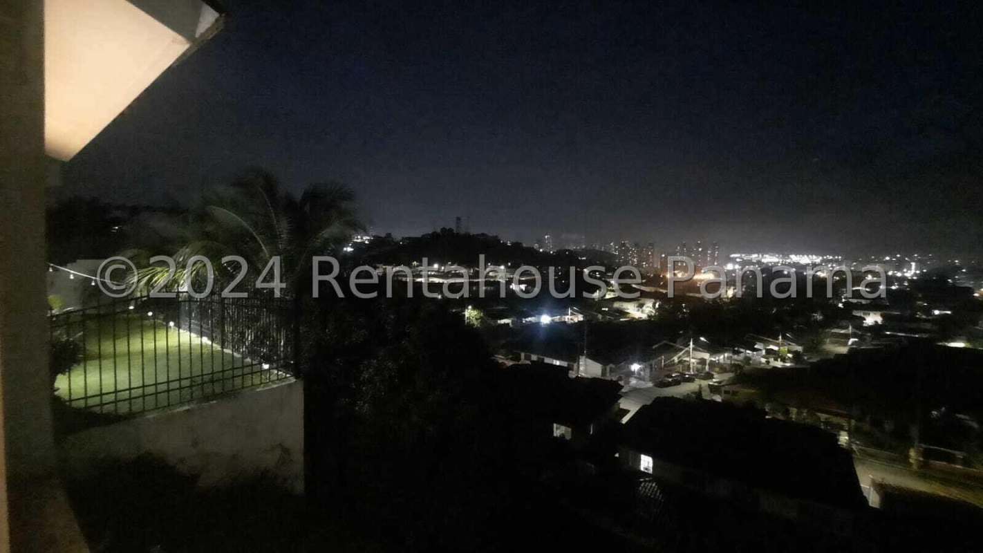 Modern kitchen with white cabinets, black dining table, ceiling fan in Altos de Panamá home