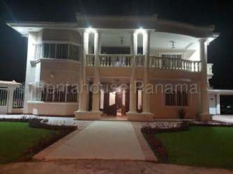 Two story luxury house exterior illuminated at night with columns Margarita Colon Panama