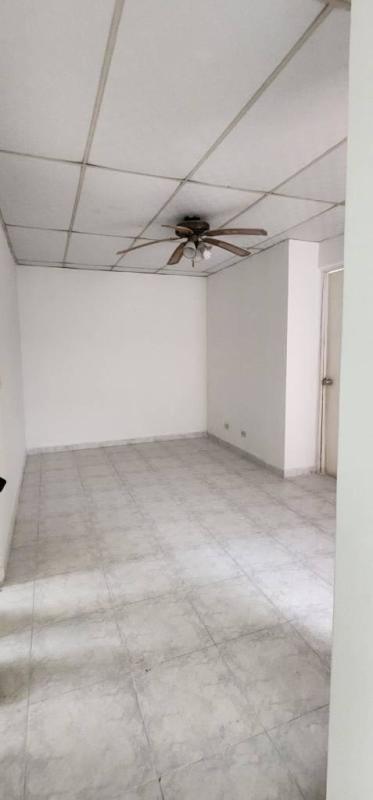 Exterior backyard view of two-story light blue house with security bars, patio, grassy yard enclosed wall in PH Colinas del Golf Brisas del Golf Panama