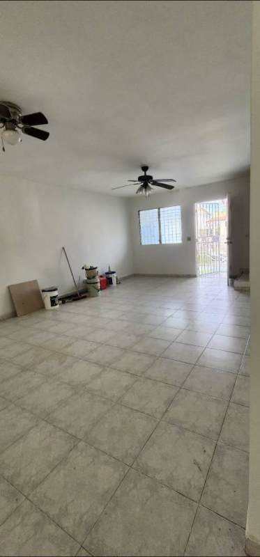 Exterior street view of townhouses with gated garages, driveway, and tiled roof in PH Colinas del Golf Brisas del Golf Panama City