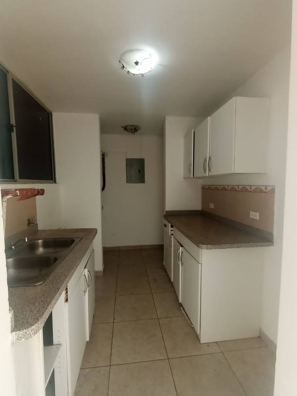 Minimalist galley kitchen with granite countertop and cabinetry in Mystic Towers Panama