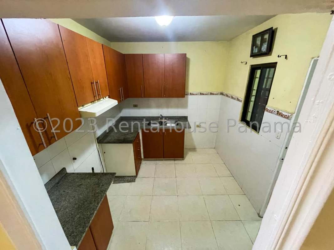 Kitchen with wooden cabinetry, granite countertops, tiled backsplash, window in house for sale Cerro Viento Panama