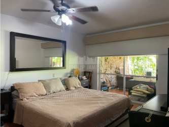 Bright living room with ceiling fan, sliding glass doors to balcony, garden views in Rio Hato villa