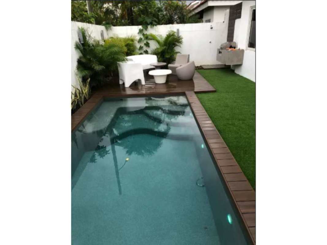 Living and dining area with large sliding doors to terrace and backyard pool in Panama City