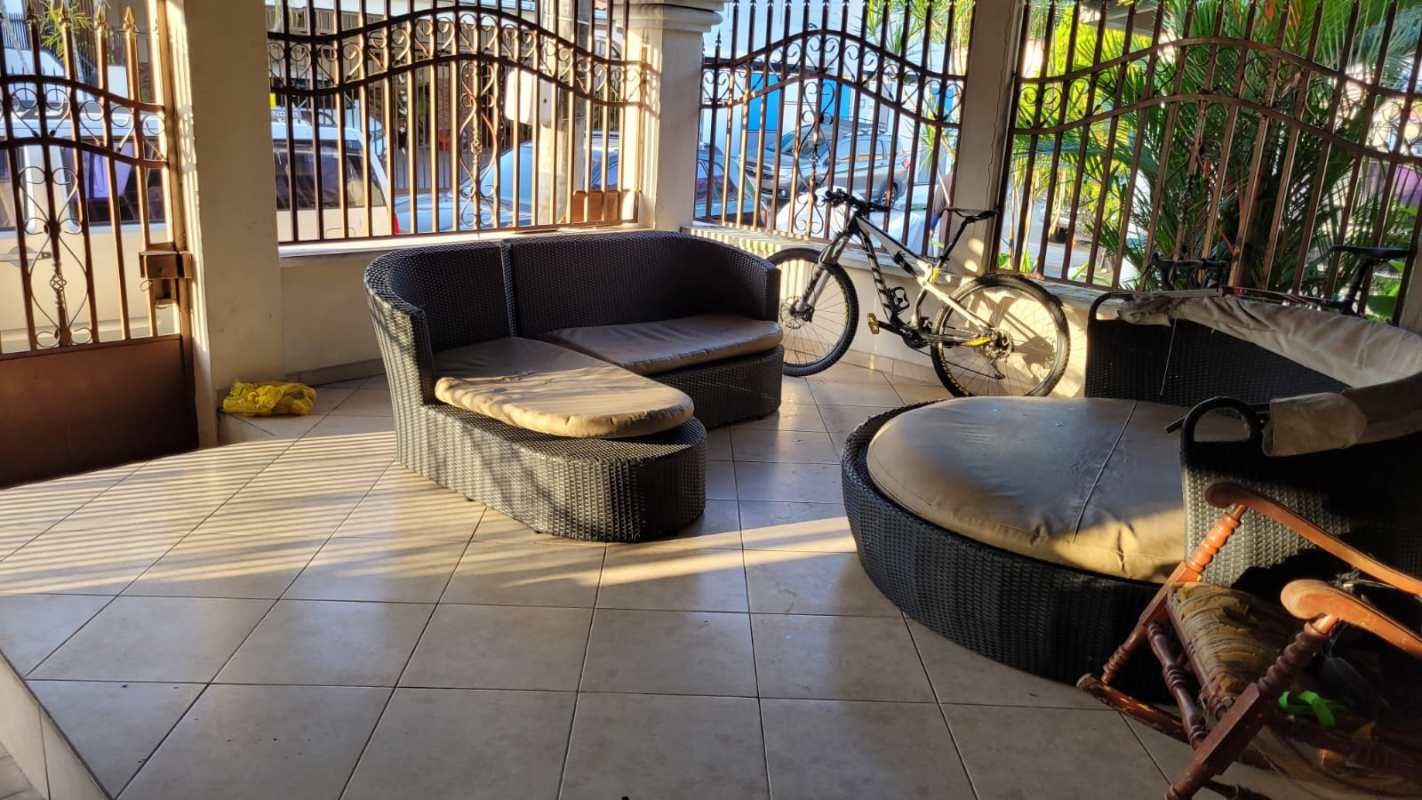 Bedroom with carved wooden bed, dresser, mirror, window with curtains, Altos de Panamá duplex
